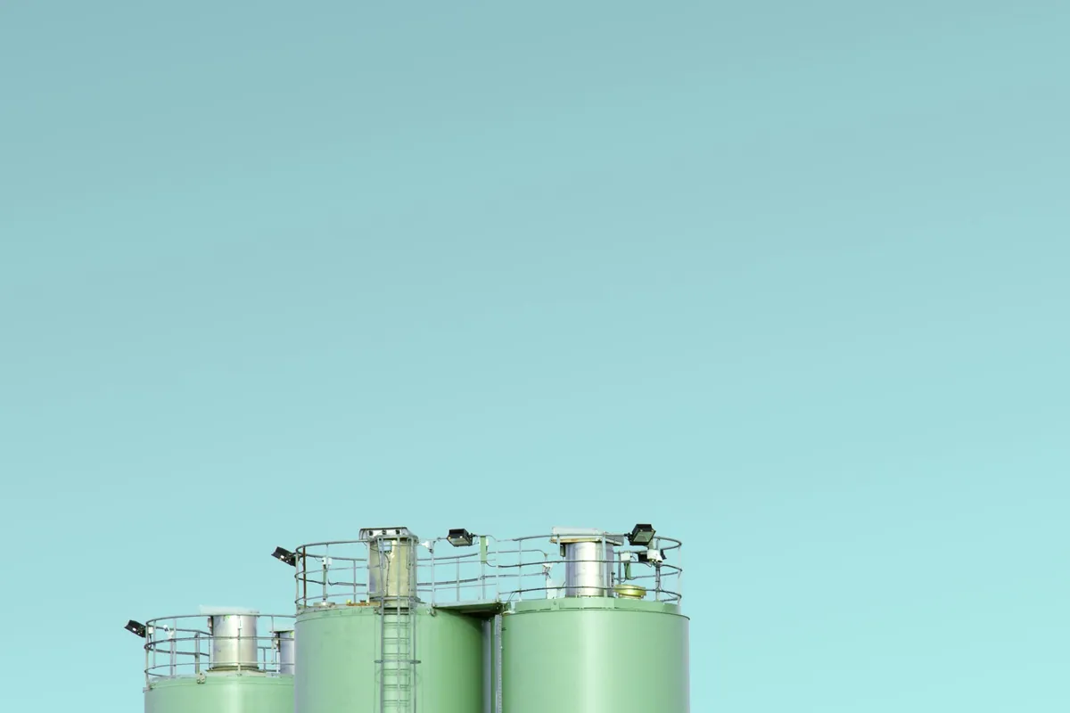 Cylindrical industrial storage silos with access platforms at the top